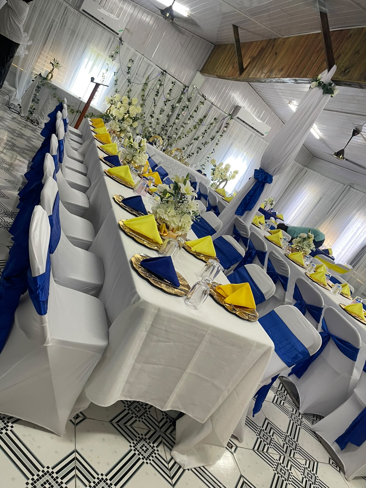 Banquet hall long table set with blue and yellow accents