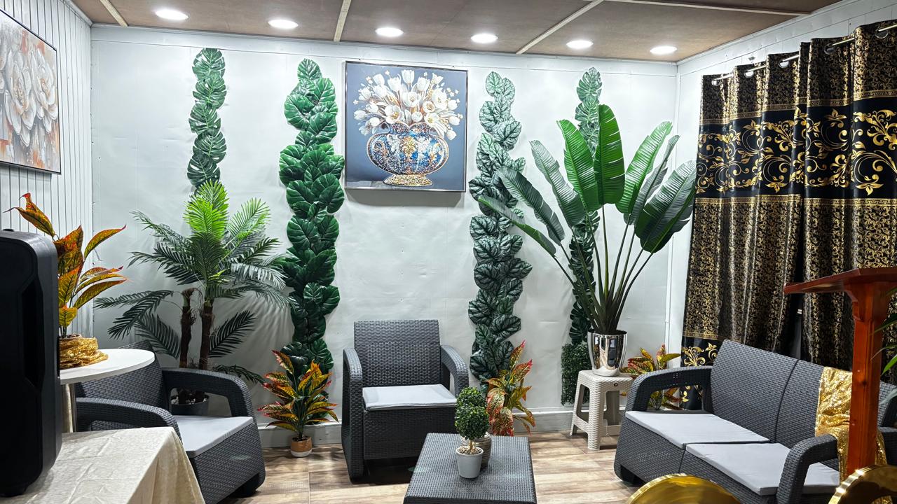 Indoor seating lounge with grey wicker furniture and faux plants
